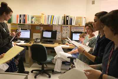 Observing hospital staff meet together to discuss the needs of each patient first-hand.