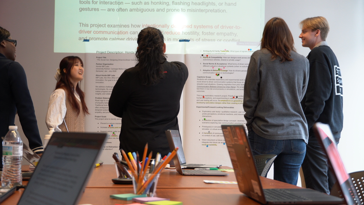 a team of students and clients brainstorm during a capstone meeting