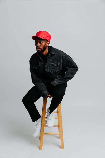 Portrait of Ian Clark, who is sitting on a stool.