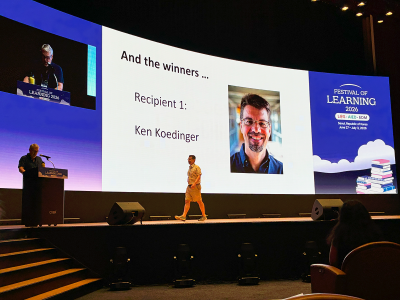 Ken Koedinger walks across the stage to receive the AIED Lifetime Achievement Award