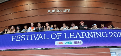 Many members of the CMU community stand near a blue 2026 Festival of Learning banner.