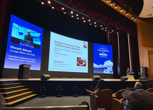 Vincent Aleven on stage giving keynote at AIED