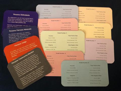 12 cards of various solid colors lay slightly overlapping on a black background