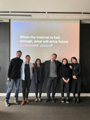 6 students on team InterDigital stand in front of projector screen with text "When the internet is fast enough, what will drive future consumers' choice?"