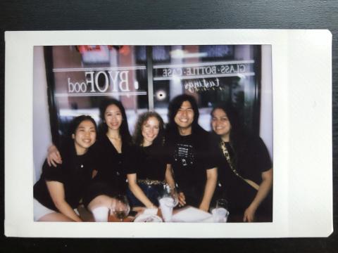 black and white Polaroid photo of the 5 students on this team at a restaurant