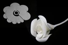 a piece of flat, white plastic being dipped in warm water and folding into a rose