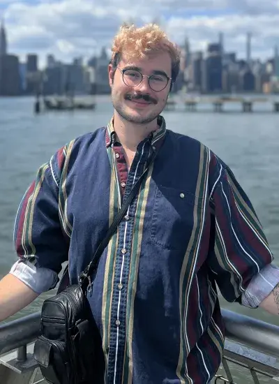 Photo of PhD Student Jordan Taylor in front of water