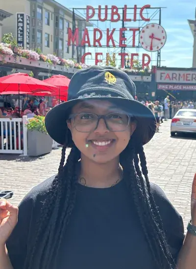 Simret outdoors in front of the Public Market Center signage