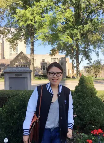 PhD Student Zheng Yao standing in front of building on sunny day