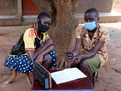 two students complete a lesson while listening to the radio