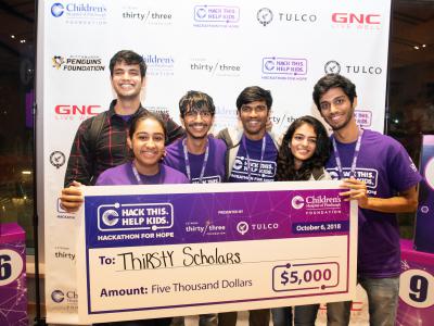 team of hackthon student winners hold large check for $5000