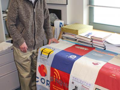 Dan Siewiorek stands beside the t-shirt quilt in his office