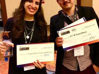 Nesra Yannier and Ken Holstein holding their award checks at the Reimagine Education competition