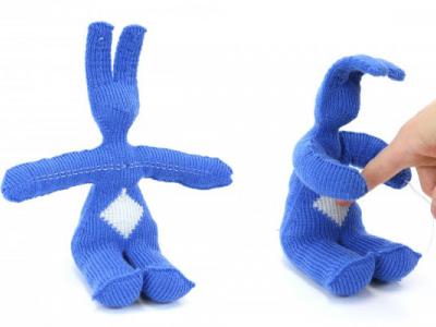 image on left: bunny knit out of blue yarn. image on right: when responsive fibers on belly are poked, bunny responds with hugging motion