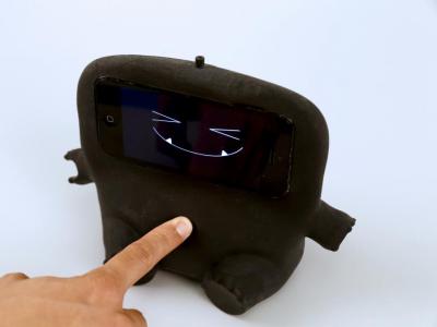 A plus doll with an iPhone head that uses the Acoustruments technology to make it interactive.