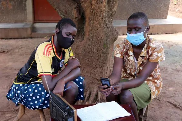 two students complete a lesson while listening to the radio