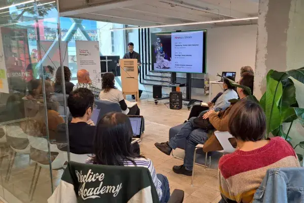 Hiro Shirado stands behind a podium while giving a CMUPortugal talk at ITI – Hub do Beato