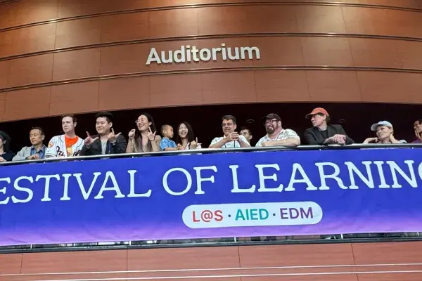 Many members of the CMU community stand near a blue 2026 Festival of Learning banner.