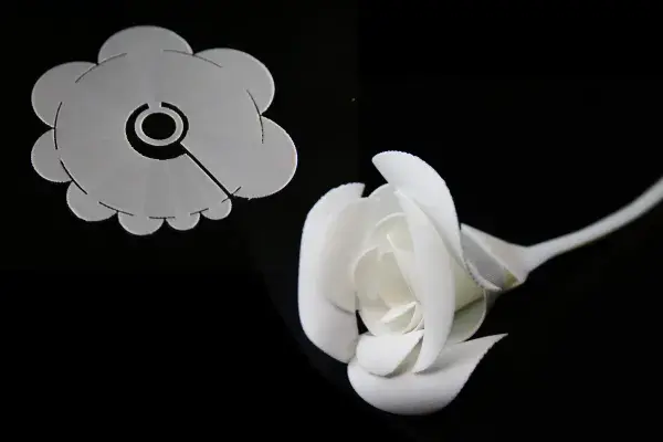 this flat, white 3D printed item self-folded into the shape of a rose when exposed to heat 