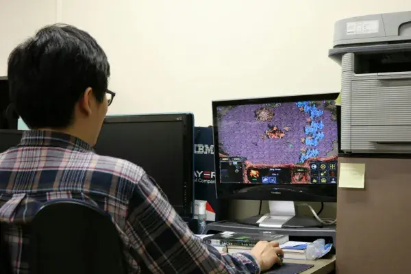 A researcher plays StarCraft against an AI player.