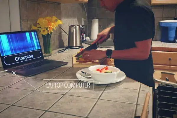 sensors in the kitchen recognize the sound of someone chopping vegetables and displays "chopping" on laptop screen
