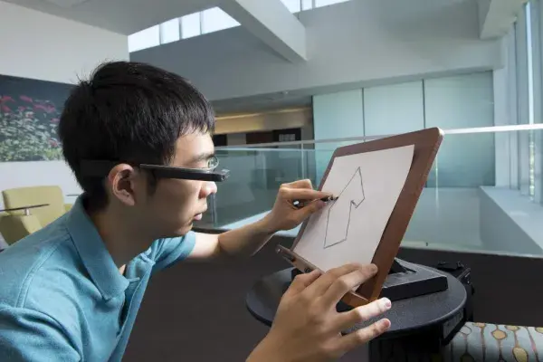 a Ph.D. student in computer science, uses a cognitive assistant that monitors his efforts at freehand sketching with a Google Glass and provides step-by-step advice.